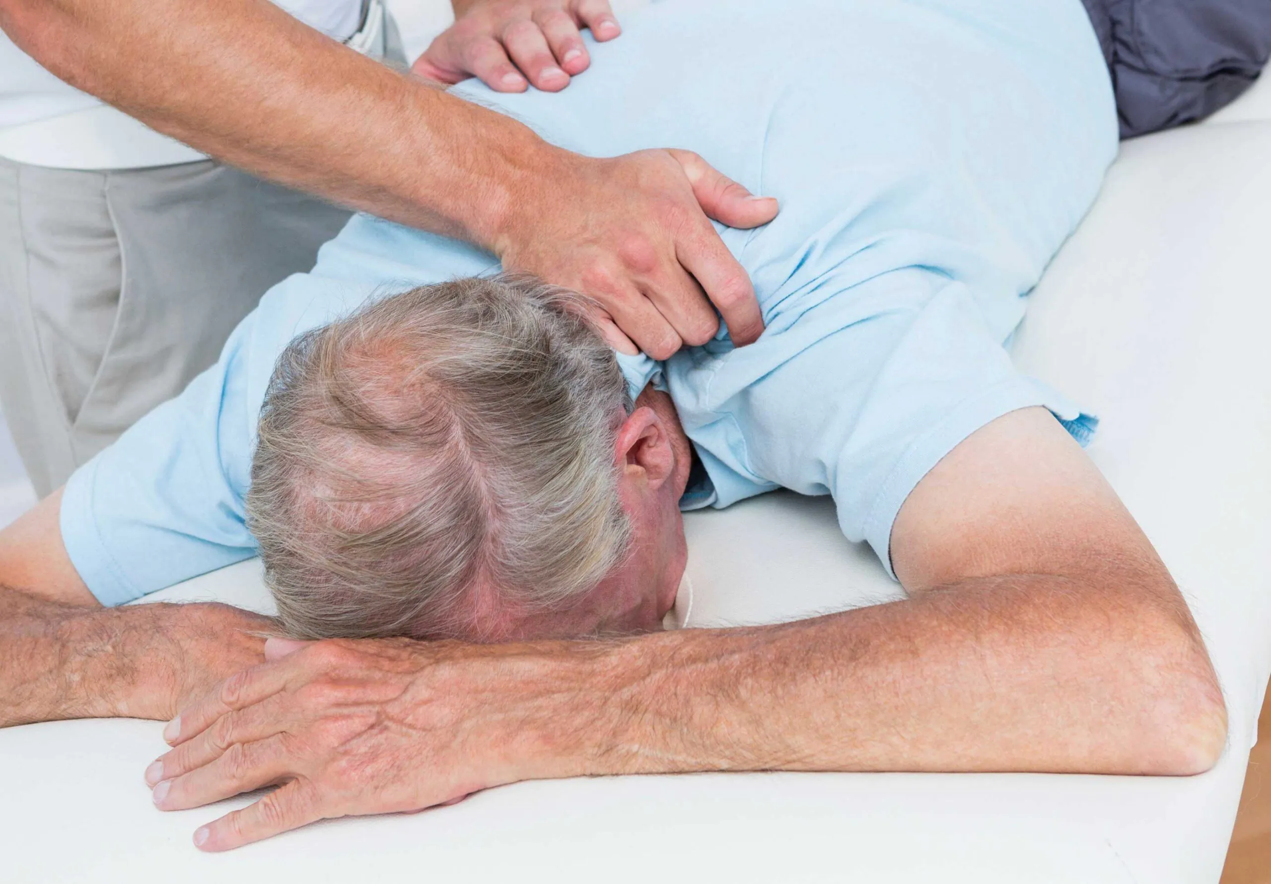 Physiotherapist doing neck massage to his patient in medical office